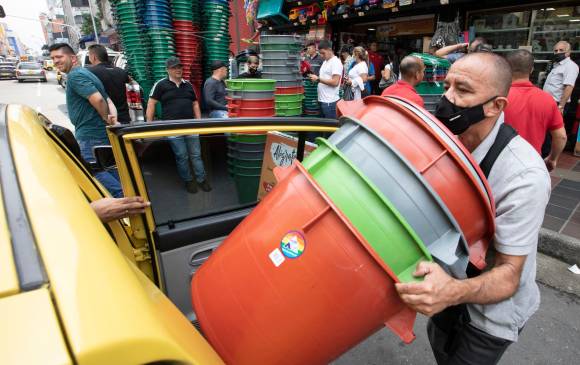 Apiladas en taxis y camionetas, pequeños comerciantes y compradores se llevaban como podían las canecas que consiguieron. Las tiendas tenían sus inventarios agotados. FOTOS EDWIN BUSTAMANTE