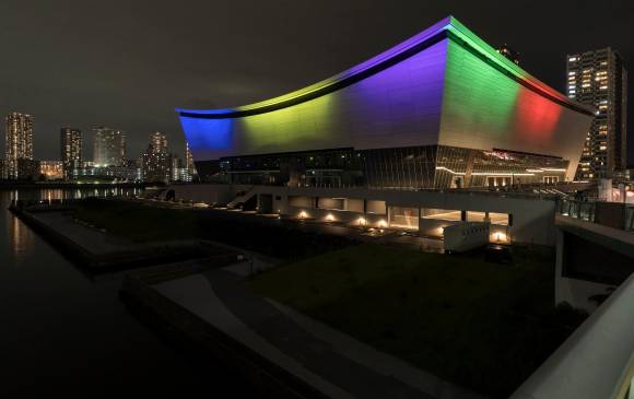 El Ariake Arena, una de las sedes principales de los Juegos Olímpicos y Paralímpicos de Tokio, es iluminada con luces de colores como símbolo olímpico en la noche. FOTOS GETTY