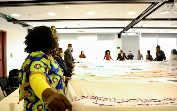 Las integrantes de La Comadre, quienes extendieron un telar pintado con mensajes de mujeres de Soacha comenzaron la entrega del informe con un ritual especial y cánticos de plegaria. FOTO JEP