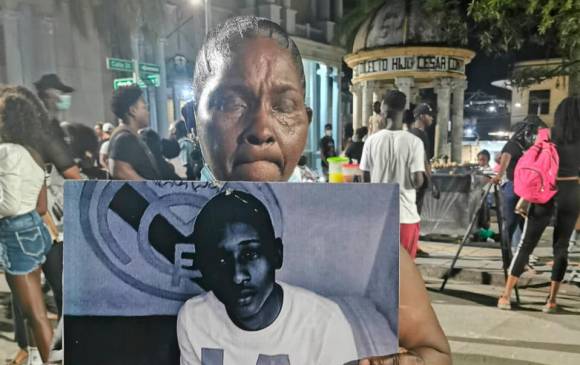 La señora Dora Borja, madre de Yadinton Mosquera Borja, muestra el rostro de su hijo, uno de los 585 jóvenes asesinados en Chocó en 6 años, en la noche de este viernes durante un homenaje a todos ellos en Quibdó. FOTO: Cortesía 