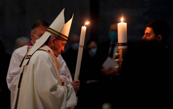 Momentos en que El Papa Francisco enciende el cirio como testimonio de la resurrección de Jesús. Foto: EFE.
