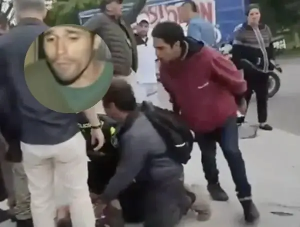 Cuando al joven sicario de 15 años lo capturan después de perseguirlo por varias cuadras y está herido de bala en una pierna, hay un hombre que lo golpea insistentemente en su cabeza. Foto: captura de video y City TV