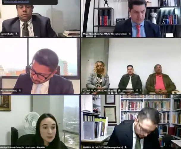 Yaneth Rúa, Misael Cadavid y Elkin González dentro de la audiencia de este miércoles. En la parte inferior izquierda, la juez Séptima Penal leyendo su veredicto. Los demás son los abogados. FOTO: IMAGEN DE LA AUDIENCIA