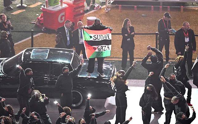 Hondeando la bandera, el hombre subió de sorpresa a un coche que hacía parte del espectáculo del medio tiempo del Super Bowl. FOTO: AFP