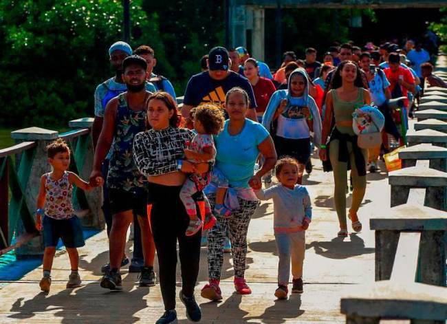 Migrantes abordando las lanchas para viajar hasta Acandí y buscar el Darién. FOTO: Camilo Suárez