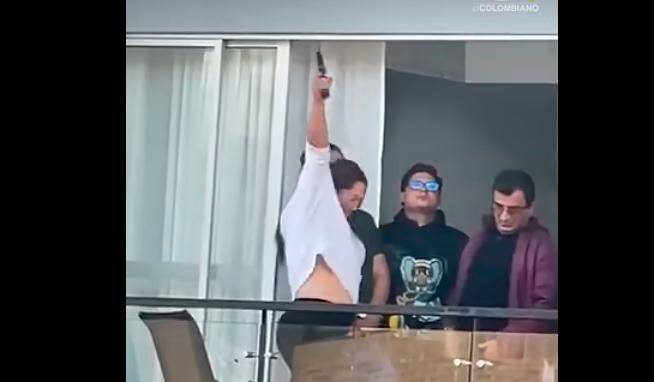 Este fue el momento, registrado por los vecinos, en los que Paola Navia Valencia usó el arma en el balcón de un apartamento. FOTO: TOMADA DE VIDEO.