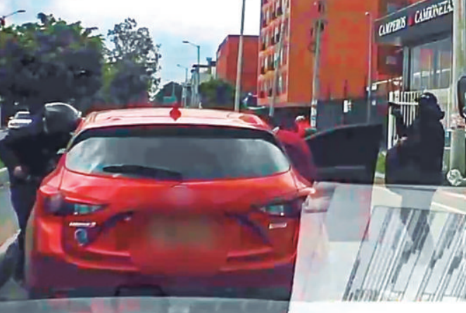 El atraco perpetrado a los ocupantes de un vehículo en la localidad bogotana de Suba. Tres delincuentes armados aprovecharon el pare del semáforo para intimidar a los ocupantes y robarles. Foto: tomada de video