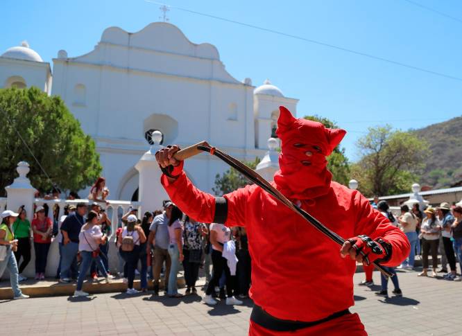 “Los Talcigüines”, cuyo nombre se deriva del náhuatl y se traduce como “hombres demonio”, son jóvenes que se visten con atuendos rojos y máscaras grotescas, representando a demonios o figuras del mal. Foto: GETTY