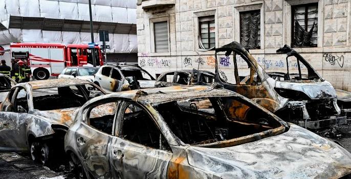 Así quedaron varios de los vehículos alcanzados por las llamas, en el centro de Milán. FOTO: AFP.