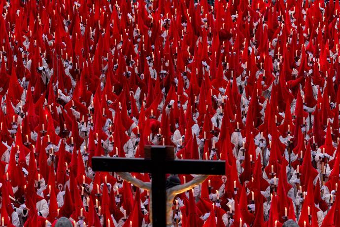 Miembros de la Real Hermandad del Santísimo Cristo de las Injurias se arrodillan frente a la catedral para hacer voto de silencio antes de participar en la Procesión del Silencio. Foto: AFP