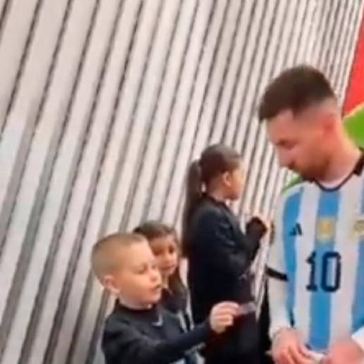 Este es el momento en el que el niño sacó de su bolsillo dos stickers y se los regala a Messi. FOTO CAPTURA DE PANTALLA
