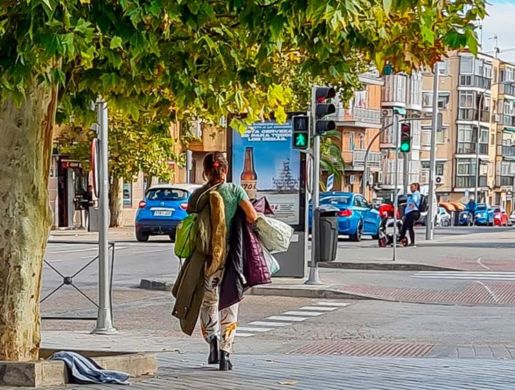Mujer drogada camina con sus pertenencias por una calle de Villaverde Alto, junto a la estación de la Renfe. FOTO: Alexander Macías