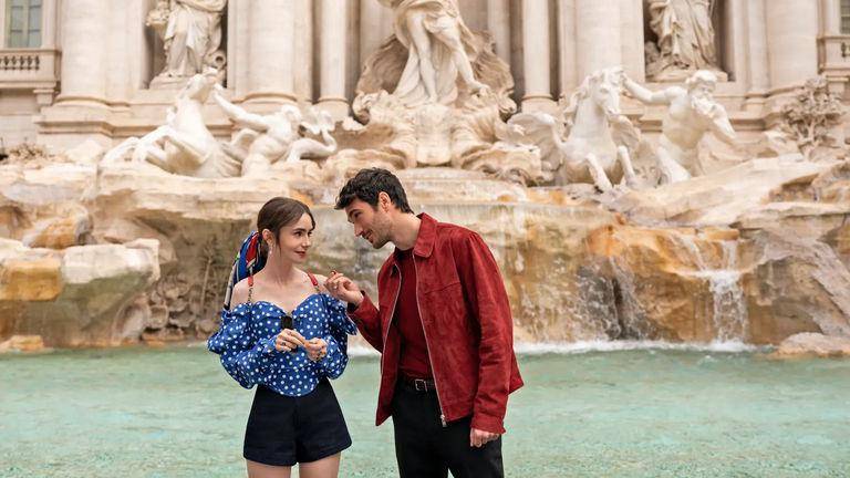 El destino de Emily Cooper la lleva a conocer al italiano Marcelo Muratori, quien la invita a conocer Roma. Aquí está conociendo la Fontana di Trevi, una de las fuentes más famosas y visitadas de la ciudad. FOTO: cortesía Netflix