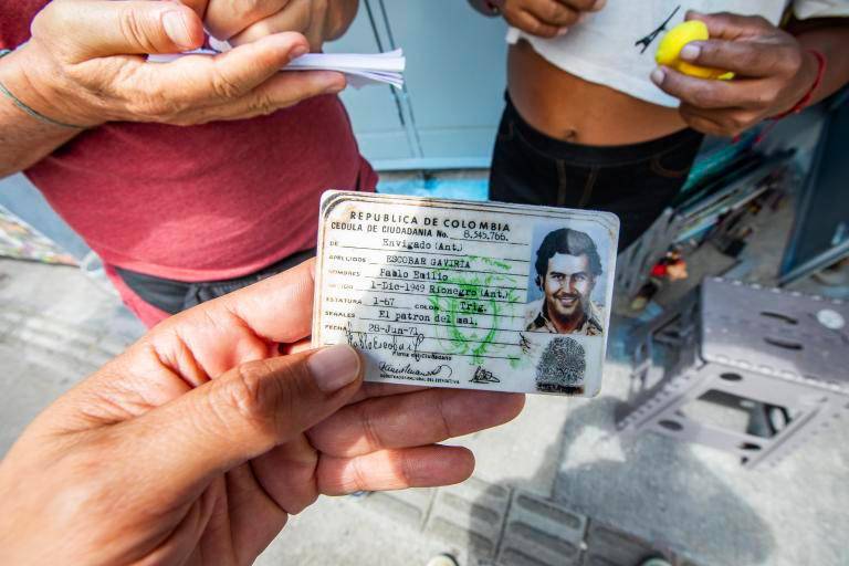 En la comuna 13 y otros sitios turísticos de la ciudad se popularizó la venta de objetos con la imagen de Pablo Escobar, como esta copia de su cédula. FOTO: ESNEYDER GUTIÉRREZ