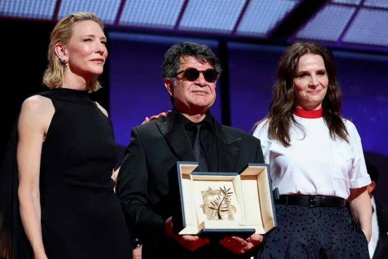 El director iraní Jafar Panahi entre Cate Blanchett y Juliette Binoche, en el Festival de Cannes el 24 de mayo de 2025. FOTO: AFP