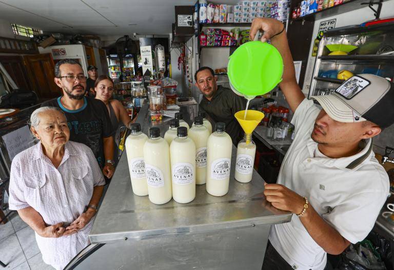 Miguel Ángel Jaramillo envasando las avenas en compañía de su padre Ómar, su abuela y su tío. Un negocio familiar que no deja de dar frutos y sigue haciendo feliz a cada cliente y visitante. FOTO Manuel Saldarriaga.
