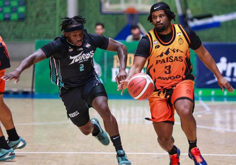 Emanuel Payton, de Toros del Valle, trata de contener a Mike Miles, de Paisas (naranja), en el duelo disputado en el Iván de Bedout. FOTO Manuel Saldarriaga 