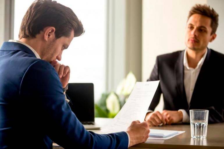Reclutador analizando la hoja de vida de un candidato en una entrevista de trabajo. FOTO: iStock