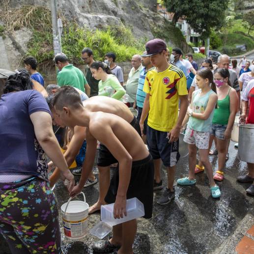 Gente haciendo fila por agua por corte del fluido de agua en un barrio de Medellín. Foto: EL COLOMBIANO