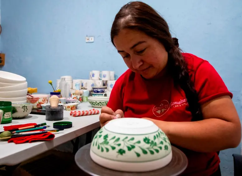 Natalia decorando otra vajilla con el diseño de Eterna en el mismo color que el que pintó al papa. FOTO Julio César Herrera