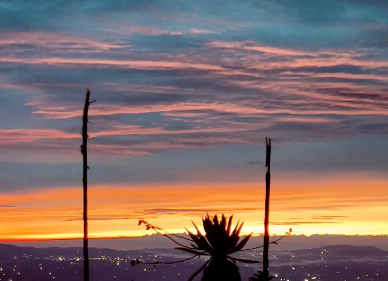 Primeros rayos de luz en el Páramo de Belmira a más de 3.350 metros de altura, con el cielo teñido de tonos rojos y naranjas, acompañados de luciernagas. Foto: Cristina Rodriguez.