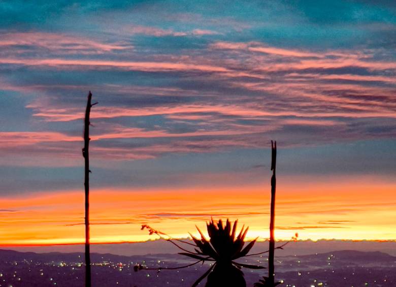 Primeros rayos de luz en el Páramo de Belmira a más de 3.350 metros de altura, con el cielo teñido de tonos rojos y naranjas, acompañados de luciernagas. Foto: Cristina Rodriguez.