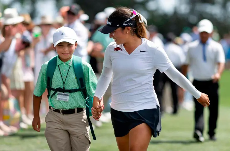 María José Marín junto a su hermano Emilio durante el recorrido tras coronarse campeona del Augusta, rumbo a la premiación. FOTO GETTY 