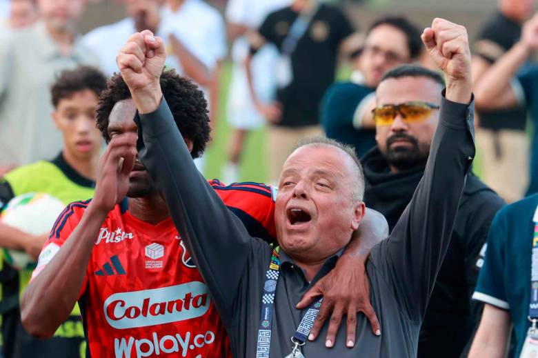 Este es el momento en el que Didier Moreno trata de sacar del campo a Raúl Giraldo, máximo accionista del DIM, quien se enfrentó a los hinchas Poderosos que terminaron molestos por la eliminación. FOTO: MANUEL SALDARRIAGA. 