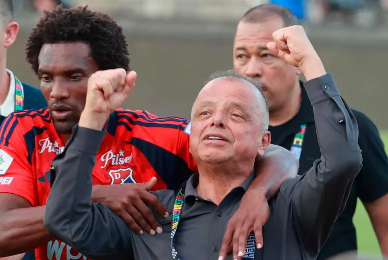 Didier Moreno trató de sacar a Raúl Giraldo del campo del Atanasio Girardot, mientras que dirigente le hacía señas a los aficionados de la tribuna occidental, quienes le reclamaban por la eliminación. FOTO MANUEL SALDARRIAGA 