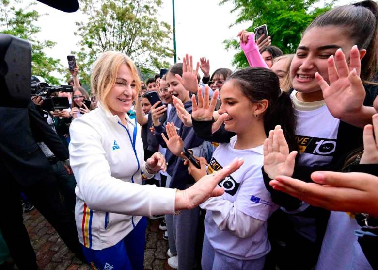La gimnasia rumana Nadia Comenaci saluda a las personas de la pequeña localidad rumana de Onesti, su ciudad natal, tras su regreso a casa. FOTOS AFP