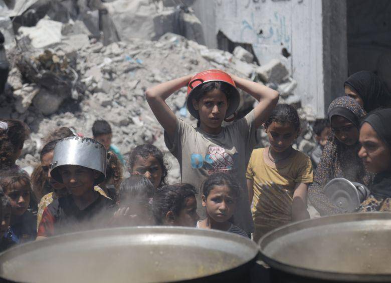 Palestinos esperan para recibir alimentos en un campamento de refugiados de Jabalia, en el norte de la Franja de Gaza, el 19 de mayo de 2025. Israel permitió entrada de suplementos humanitarios después de mantener el bloqueo en el territorio palestino desde el 2 de marzo. FOTO: Xinhua