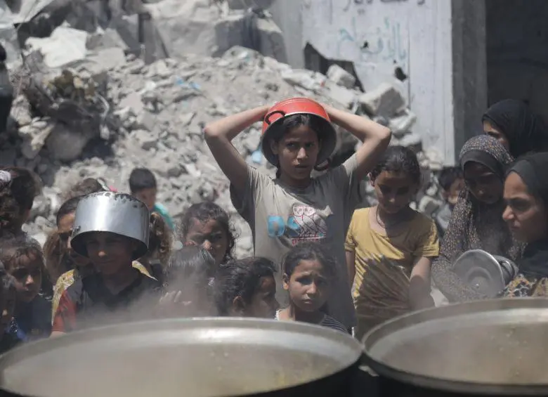Palestinos esperan para recibir alimentos en un campamento de refugiados de Jabalia, en el norte de la Franja de Gaza, el 19 de mayo de 2025. Israel permitió entrada de suplementos humanitarios después de mantener el bloqueo en el territorio palestino desde el 2 de marzo. FOTO: Xinhua