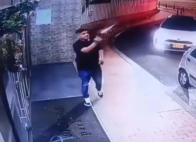 El hombre fue grabado realizando al menos 12 disparos al aire en la entrada de un conjunto residencial en el norte de Bogotá. FOTO: captura de video. 