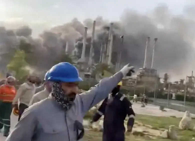 Los trabajadores evacúan el área alrededor de la refinería de petróleo Ras Tanura de Saudi Aramco mientras se eleva el humo luego de un reportado ataque con drones iraníes en Arabia Saudita. FOTO: Tomada de Al Jazeera.