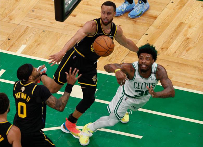 El escolta de los Boston Celtics, Marcus Smart (der.), en acción contra el escolta de los Golden State Warriors, Gary Payton II (izq.), y el escolta de los Golden State Warriors, Stephen Curry (c), durante la primera mitad del Juego 3 de las finales de la Asociación Nacional de Baloncesto (NBA). entre los Boston Celtics y los Golden State Warriors en el TD Garden, en Boston, Massachusetts. FOTO EFE