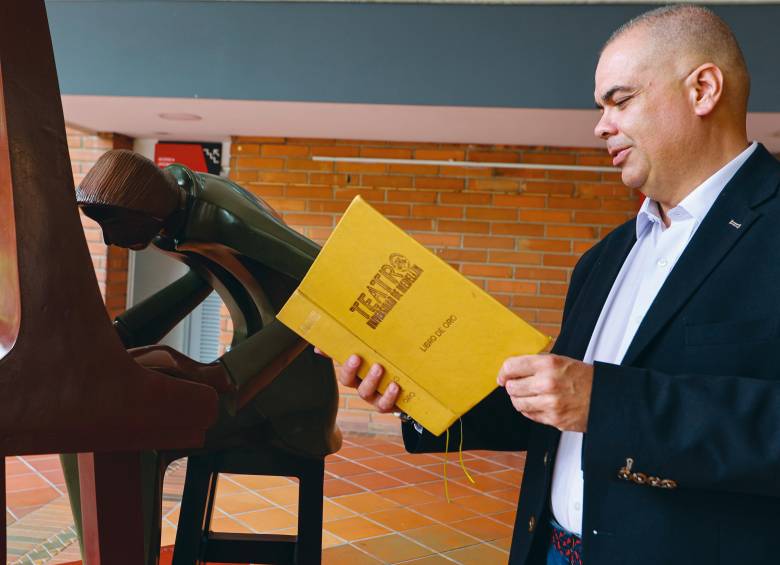 Juan Carlos Cespedes, director del teatro de la Universidad de Medellín, sostiene un libro con mensajes de los artistas que se han presentado allí. FOTO manuel saldarriaga 