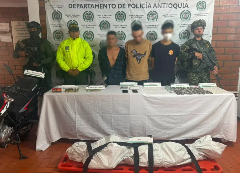 En la imagen, unos de los detenidos en el operativo de Salgar junto al cuerpo del presunto delincuente abatido. FOTO: Cortesía