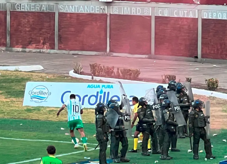Esta imagen fue recurrente durante todo el partido: la lluvia de botellas y bengalas, además de los vidrios rotos del bus, también se viralizaron. FOTOS TOMADAS DE X Y NACIONAL