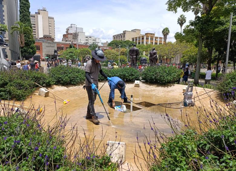 Aseadores limpiando una de las fuentes ubicadas en uno de los costados de la Plaza de Botero. Foto: Julio César Herrera Echeverri.