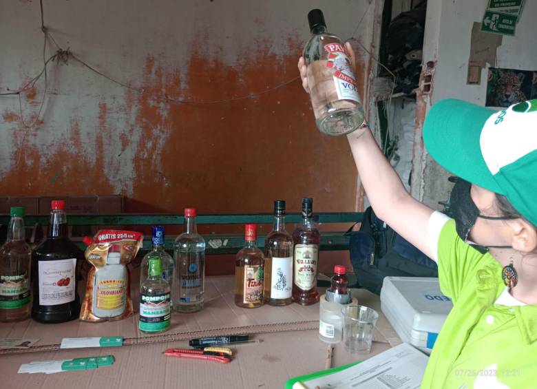 Una de las funcionarias de la Gobernación de Antioquia analiza el licor adulterado incautado