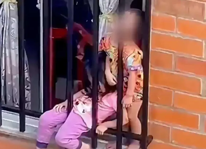Dos menores en una ventana genera investigación por presunto maltrato infantil en Risaralda. FOTO: Captura de video 