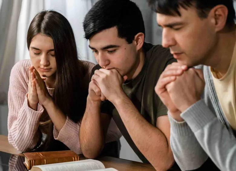 Durante la noche del 31 de diciembre, familias se reúnen para compartir un momento de oración que acompaña el cambio de año y refuerza los lazos de fe y comunidad. FOTO: Freepik. 