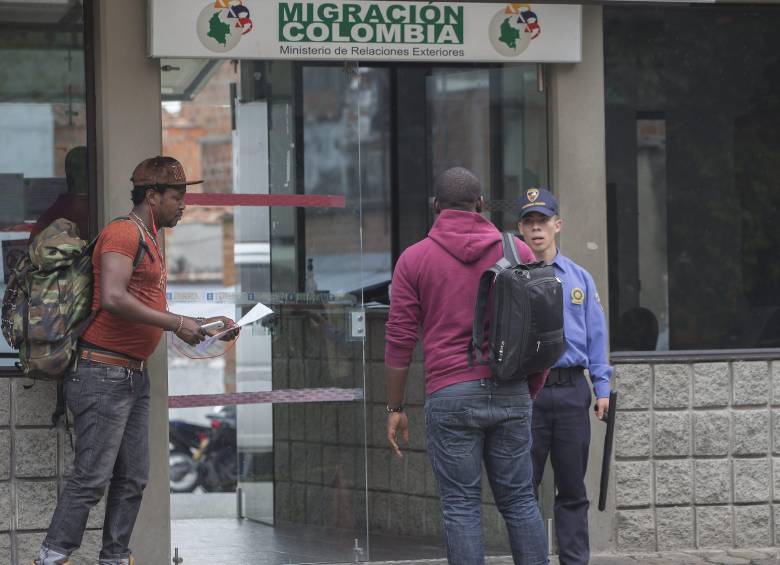 Imagen de referencia de unos migrantes realizando trámites en una oficina de Migración Colombia en Medellín. Foto: Julio César Herrera Echeverri