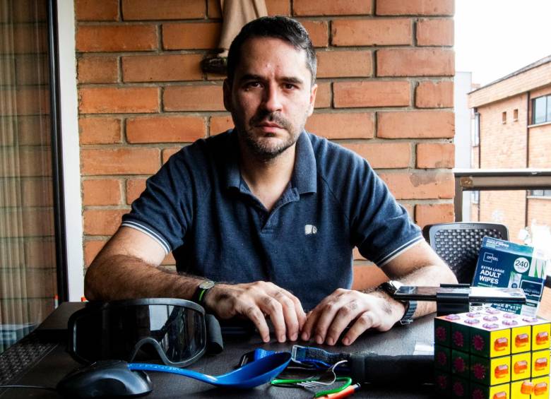 Felipe Betancur y algunos de sus inventos, entre ellos, el “mouse para pie” que tiene como base un cucharón plástico de cocina. FOTO Julio César Herrera.