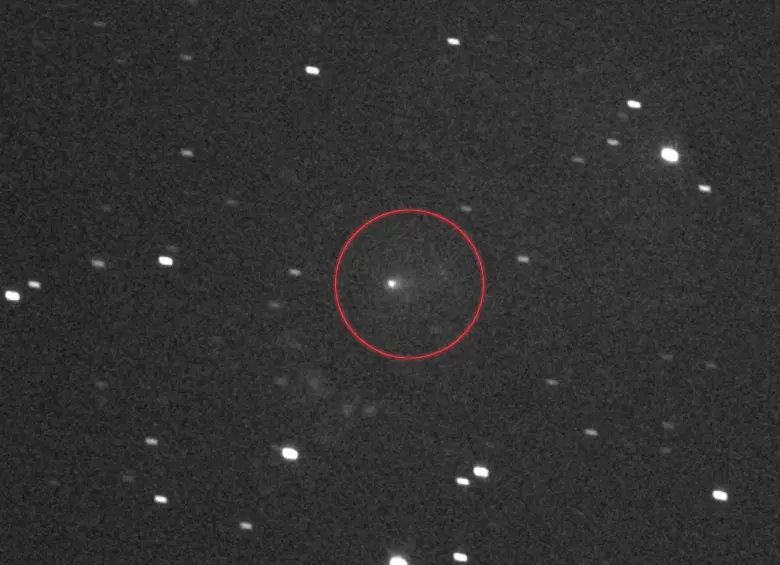 Misión Lucy de la Nasa | El cometa interestelar 3I/ATLAS, señalado con un círculo en el centro, visto por el generador de imágenes pancromáticas — o en blanco y negro — del instrumento L’LORRI a bordo de la nave espacial Lucy de la Nasa. Esta imagen fue creada mediante la superposición de una serie de imágenes tomadas el 16 de septiembre de 2025, cuando el cometa se acercaba a Marte a toda velocidad. En ese momento, Lucy estaba a 386 millones de kilómetros (240 millones de millas) de distancia de 3I/ATLAS y se dirigía a explorar ocho asteroides que comparten órbita con Júpiter y que forman parte de dos grupos conocidos como los asteroides troyanos de Júpiter. L’LORRI captó la coma del cometa, el halo borroso de gas y polvo alrededor de 3I/ATLAS, arriba, y su cola, una mancha de gas que fluye hacia la derecha del cometa. Esta imagen abarca unos 11 minutos de arco del cielo, o alrededor de un tercio del ancho de la luna llena. El norte del sistema solar está arriba. FOTO: Nasa, Goddard, SwRI y JHU-APL