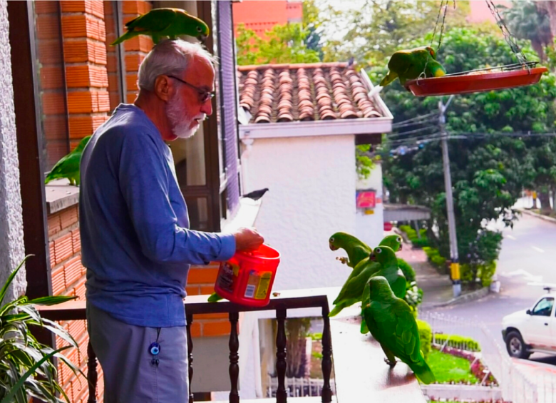 Don Guille alimenta a sus loras con cacahuates. FOTO: JUAN SEBASTIÁN CARVAJAL
