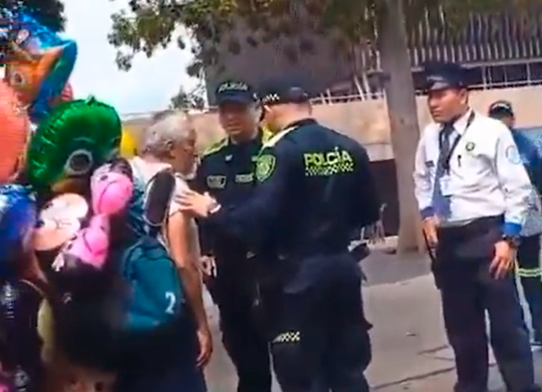 En el video se observa al adulto mayor rodeado por policías, mientras la mujer que graba alega con el supuesto agresor. 