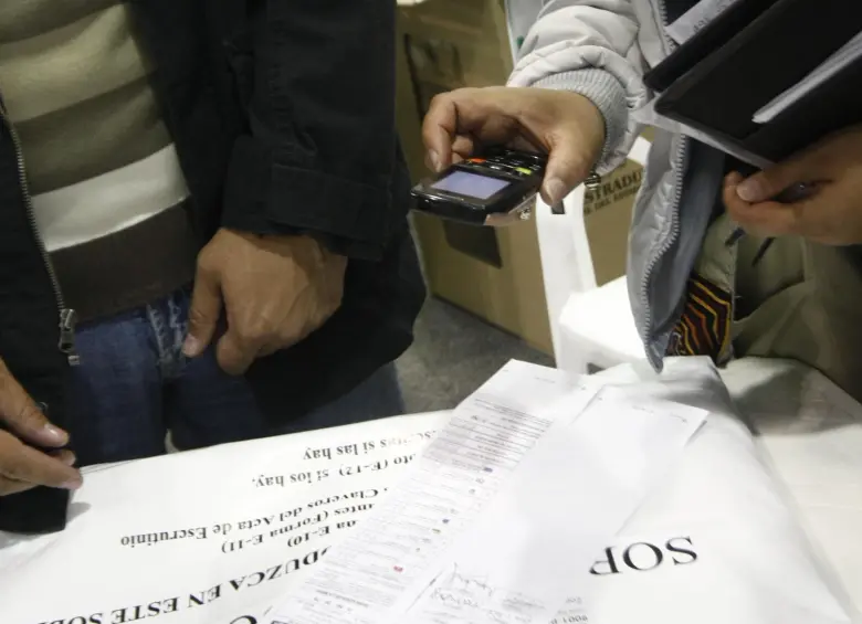 Una testigo electoral toma una fotografía del Formulario E-14 con su celular. Foto: Colprensa - Christian Castillo