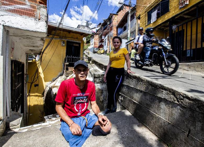 Yuliana y Jorge tomando el sol, como les gusta, en la acera de su casa en Santo Domingo Savio, Medellín. FOTO: Julio Cesar Herrera