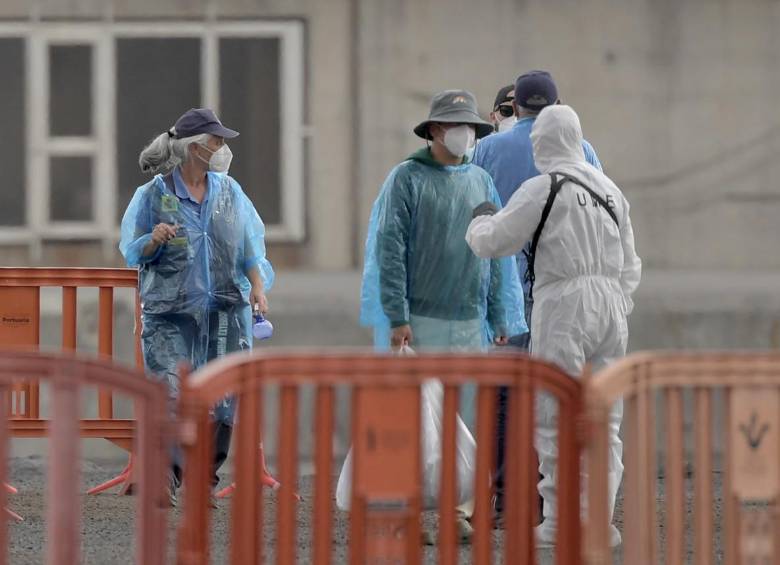 Con trajes de protección, desinfecciones constantes, separadores con pantallas profilácticas y otras seguridades, se ha realizado el desembarco y traslado de los pasajeros del crucero. Foto: Jorge Guerrero / AFP